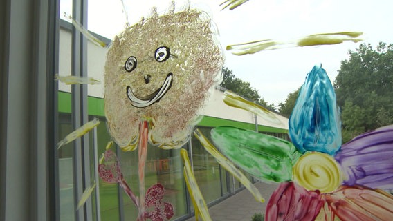 Ein bemaltes Fenster mit einer Sonne in einer Pflegeeinrichtung für Kinder mit Behinderungen. © NDR 