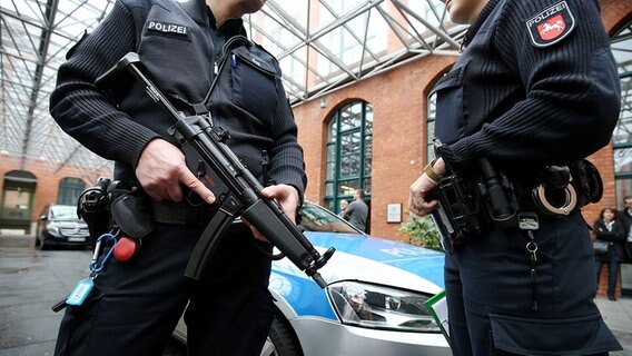Polizeikräfte stehen vor einem Hotel in Hannover. © dpa - Bildfunk Foto: Christian Charisius
