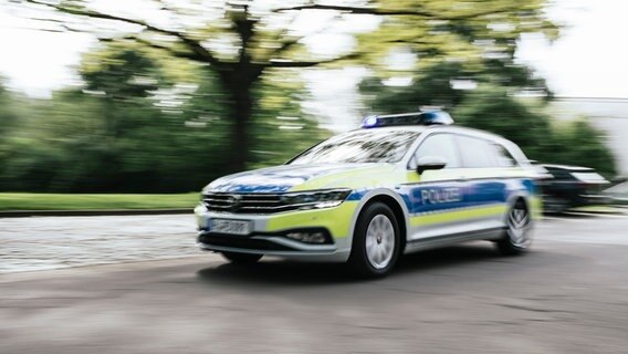 Ein Polizeiauto in Unschärfe fährt mit Blaulicht eine Straße in Hannover entlang. © NDR Foto: Julius Matuschik