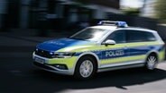 Ein Polizeiauto in Unschärfe fährt mit Blaulicht eine Straße in Hannover entlang. © NDR Foto: Julius Matuschik