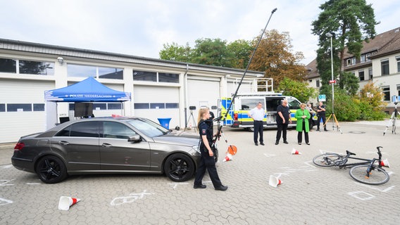 Eine Polizistin zeigt in der ZPD Zentralen Polizeidirektion Niedersachsen die Verkehrsunfallaufnahme mithilfe einer an einem Hochstativ montierten Kamera für Übersichtsaufnahmen. © dpa-Bildfunk Foto: Julian Stratenschult