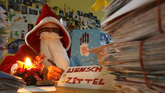 Im Weihnachts-Postamt Himmelsthür in Hildesheim und beantwortet ein Mench im Weihnachtsmannkostüm Wunschzettel. © picture alliance/dpa/Jochen Lübke Foto: Jochen Lübke