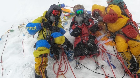 Drei Menschen liegen auf einem Berggipfel. © Jeet BahadurяTamang Foto: Jeet BahadurяTamang