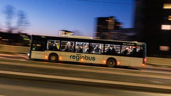 Ein Bus der Regiobus Hannover GmbH fährt in der Morgendämmerung über eine Brücke. © picture alliance / dpa Foto: David Hutzler