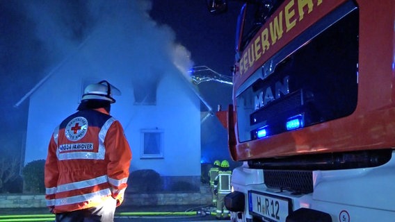 Einsatzkräfte der Feuerwehr stehen vor einem brennenden Haus in Ronnenberg. © TeleNewsNetwork 