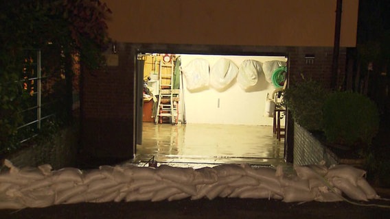 Sandsäcke liegen vor einer beleuchteten Garage. © NonstopNews 