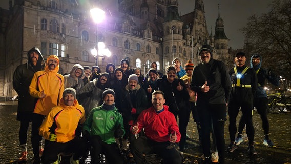 Männer posieren mit Schnurrbärten für ein Foto vor dem Rathaus in Hannover. © NDR Foto: Bernd Reiser