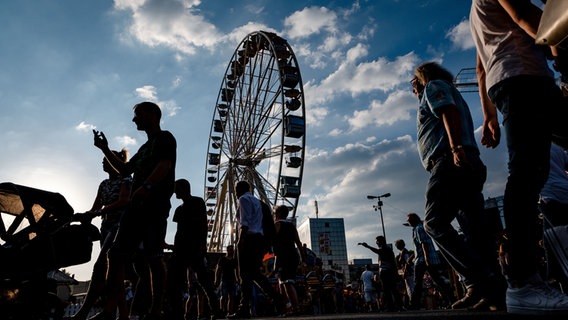 Besucher des Schützenfest in Hannover gehen vor dem Riesenrad entlang. © dpa-Bildfunk Foto: Peter Steffen