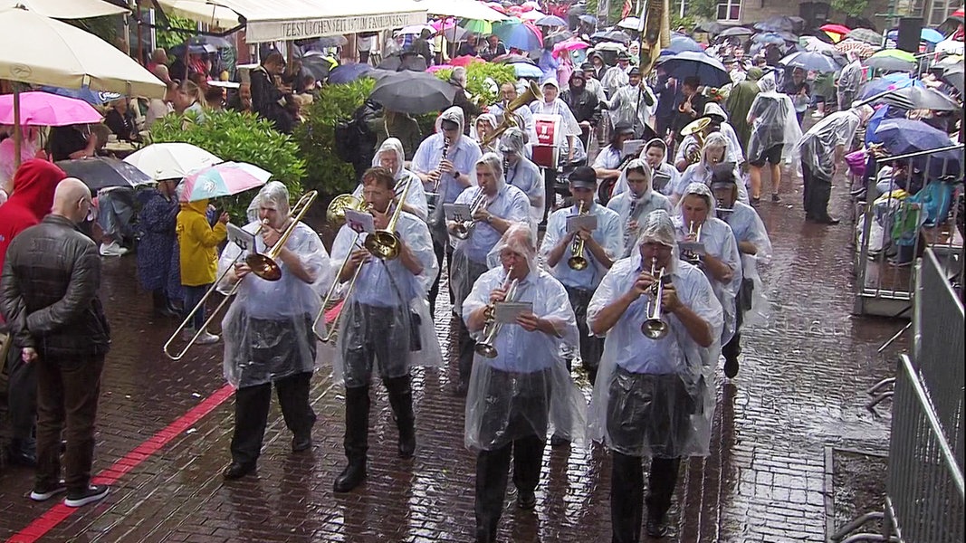 Zahlreiche Menschen nehmen bei Regenwetter am Schützenausmarsch in Hannover teil.