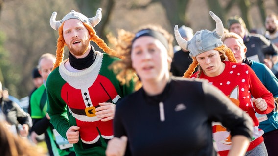 Kostümierte Teilnehmer rennen beim Silvesterlauf um den Maschsee in Hannover am 31.12.2019. © dpa-Bildfunk Foto: Moritz Frankenberg