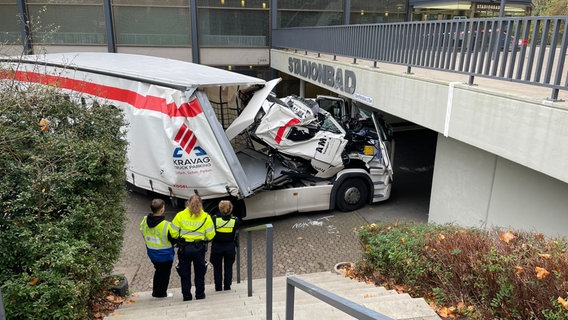 Ein Lkw ist unter einer Brücke am Stadionbad hängengeblieben. Polizisten sehen sich den Unfallschaden an. © Frank Tunnat Foto: Frank Tunnat