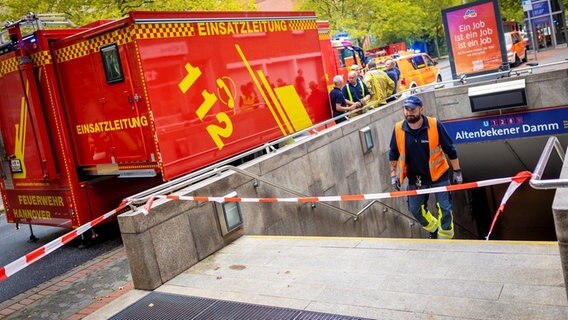 Ein Mitarbeiter der Üstra steigt die Treppen aus einer Stadtbahn-Station herauf. Auf der Straße steht ein Einsatzfahrzeug der Feuerwehr mit der Aufschrift "Einsatzleitung". © dpa Bildfunk Foto: Moritz Frankenberg