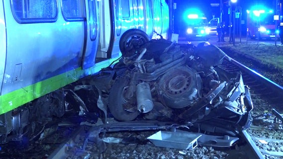 Ein schwer demolierter Pkw liegt nach einem Unfall mit einer Straßenbahn in Hannover auf den Schienen. © dpa-Bildfunk 