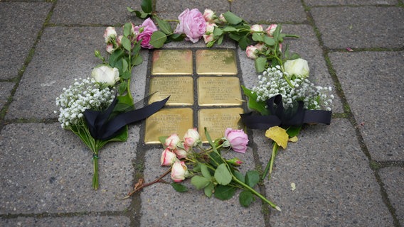 Blumen liegen neben goldenen Stolpersteinen auf dem Boden. © Stadt Seelze 