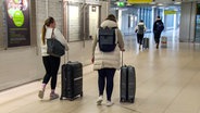 Passagiere, die wegen eines Streiks von Hamburg nach Hannover umgeleitet wurden, gehen durch den Flughafen. © NonstopNews 