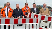 Timo Quander (Präsident Landesstraßenbaubehörde Niedersachsen), Thomas Vielhaber (Stadtbaurat von Hannover), Olaf Lies (Verkehrsminister Niedersachsen), Gero Hocker (Staatssekretär beim Bundesminister für Digitales und Verkehr) und Eric Oehlmann (Leiter der Generaldirektion Wasserstraßen und Schifffahrt) bei der Einweihung der Ersatzbrücke am Südschnellweg in Hannover. © NDR Foto: Bertil Starke