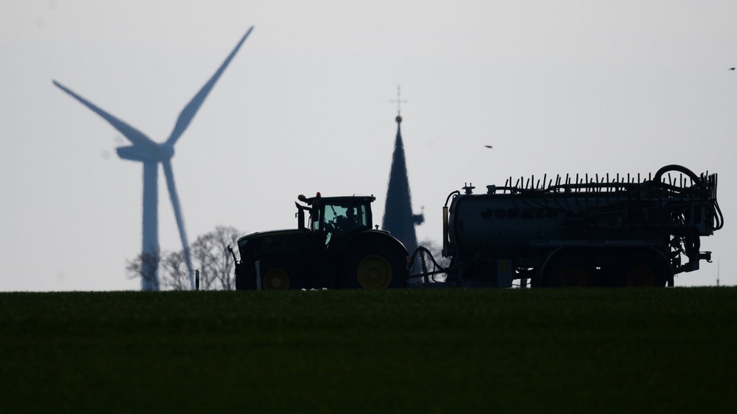 Ein Landwirt fährt mit einem Traktor und Gülleanhänger über einen Feldweg im Landkreis Hildesheim. 