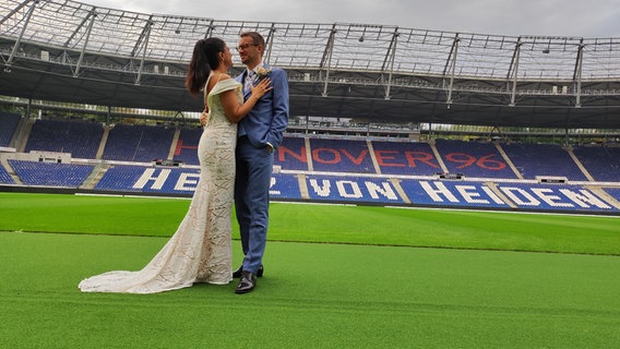 Eine Ehepaar steht nach der Trauung im Stadion von Hannover 96. © NDR Foto: Svenja Estner