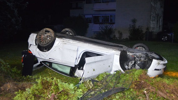 Ein weißer Tesla liegt nach einem Unfall auf dem Dach. © Polizeiinspektion Nienburg / Schaumburg 