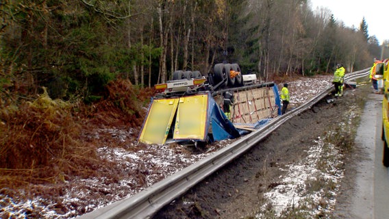 Der Anhänger eines Lkw liegt auf dem Grünstreifen der Autobahn 7. © NonstopNews 