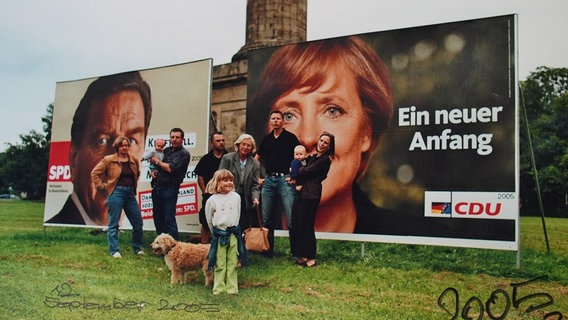 Das Bild zeigt die Familie aus Gehrden vor einem Wahlplakat im Jahr 2005. © Familie Riese 