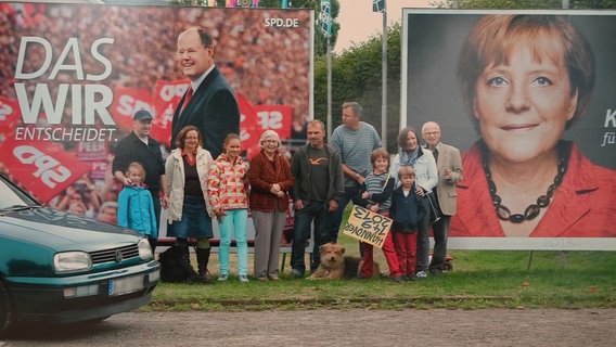 Das Bild zeigt die Familie aus Gehrden vor einem Wahlplakat im Jahr 2013. © Familie Riese 