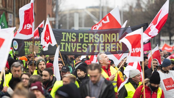 Teilnehmer einer Verdi-Demonstration laufen mit einem Banner mit der Aufschrift «Ins Personal investieren» durch die Innenstadt von Hannover. © Michael Matthey/dpa Foto: Michael Matthey