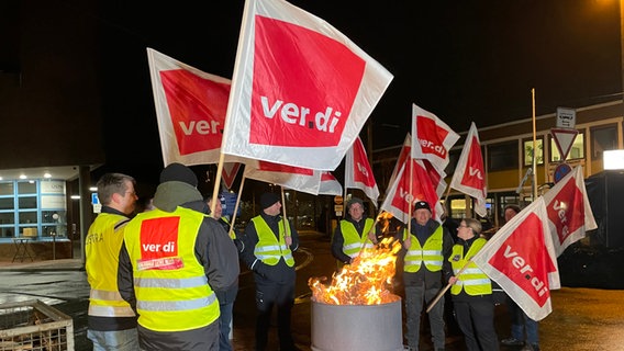 Beschäftigte der Üstra stehen bei einem Warnstreik um eine Feuertonne. © NDR Foto: Vera Zellmer