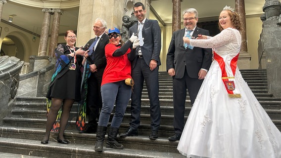 Im Rathaus in Hannover schneiden an Weiberfastnacht verkleidete Frauen Männern die Krawatten durch. © NDR Foto: Svenja Nanninga