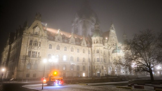 Ein kleines Räumfahrzeug streut Salz vor dem Neuen Rathaus bei Nebel und Temperaturen unter dem Gefrierpunkt. © dpa Foto: Julian Stratenschulte