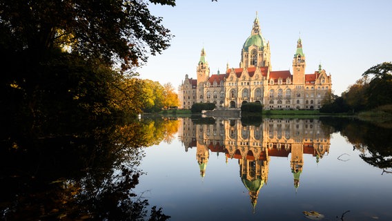 Eine großes Gebäude spiegelt sich in einem Teich. © dpa-Bildfunk Foto: Julian Stratenschulte/dpa