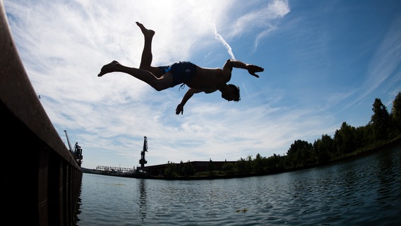 Ein Mann springt ins kühle Nass am Stichkanal Hannover-Linden. © dpa-Bildfunk Foto: Julian Stratenschulte