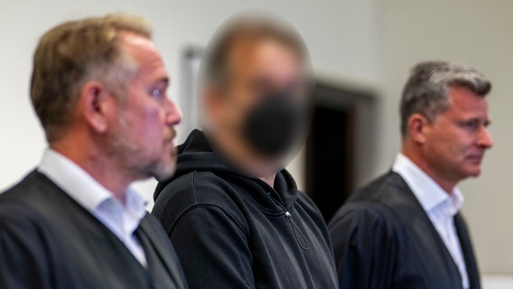Der Angeklagte Wilfried W. steht zu Prozessbeginn inmitten seiner Anwälte Carsten Ernst (l) und Detlev Otto Binder. © dpa-Bildfunk Foto: David Inderlied