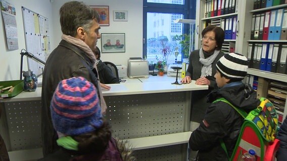 Fahad Hudsch steht mit zwei Kindern in einem Büro. © NDR 