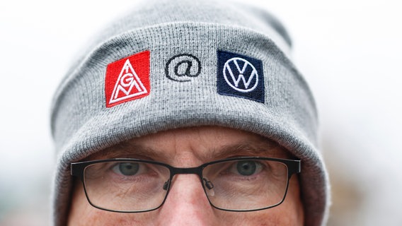 Ein VW-Mitarbeiter trägt zu den Tarifverhandlungen von Volkswagen und IG Metall eine Mütze mit IG Metall-Logo und Volkswagen-Logo. © picture alliance/Jochen Eckel Foto: Jochen Eckel