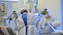 Intensivpflegerinnen sind auf der Covid-19 Intensivstation mit der Versorgung von Corona-Patienten beschäftigt.