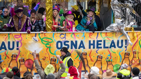 Menschen feiern beim Karnevalsumzug in Osnabrück. © picture alliance/dpa | Friso Gentsch Foto: 216493198