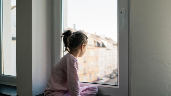 Ein Mädchen schaut aus dem Fenster. © picture alliance / Westend61 Foto: Joseffson