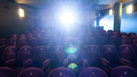 Der Filmprojektor leuchtet in den Kinosaal. © dpa-Bildfunk Foto: Julian Stratenschulte/dpa