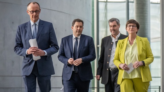 Friedrich Merz (CDU), Lars Klingbeil (SPD), Markus Söder (CSU) und Saskia Esken laufen nebeneinander durch den Bundestag. © picture alliance/dpa Foto: Michael Kappeler