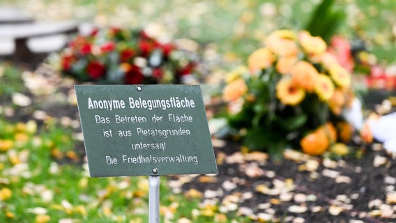 Ein Schild weist auf eine anonyme Begräbnisstelle auf einem Landschaftsfriedhof hin. © dpa-Bildfunk Foto: Jens Kalaene