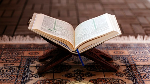 Ein geöffneter Koran steht auf einem Gebetsteppich. © picture alliance / Geisler-Fotopress | Dwi Anoraganingrum/Geisler-Fotop 