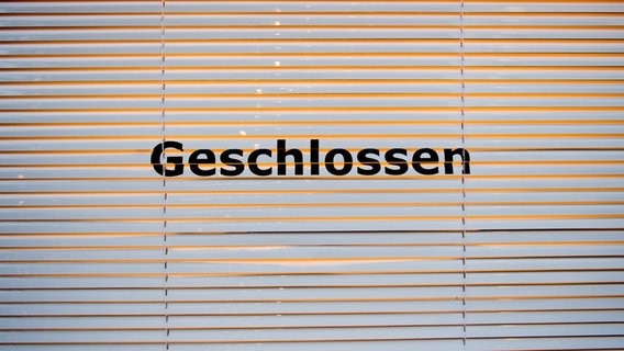 Auf einer Jalousie steht "Geschlossen". © dpa Foto: Sebastian Gollnow