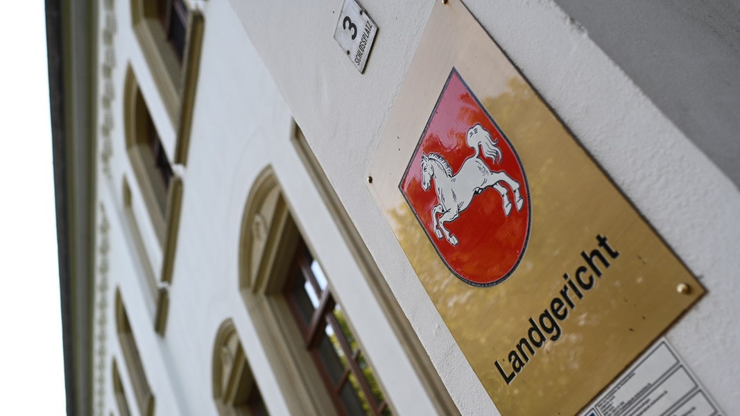 Ein Schild mit dem niedersächsischen Landeswappen hängt am Eingang zum Landgericht Aurich.