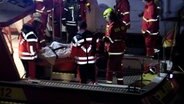 Rettungskräfte heben einen Mann auf einer Trage von einem Rettungsboot. © Hellwig TV-Elbnews Produktion 