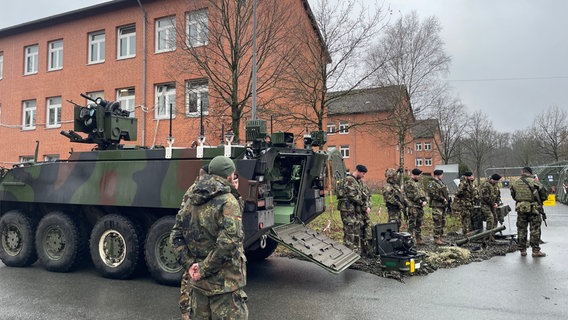 Soldaten bereiten sich auf einem Kasernengelände auf ein Manöver vor. © NDR Foto: Jon Mendrala