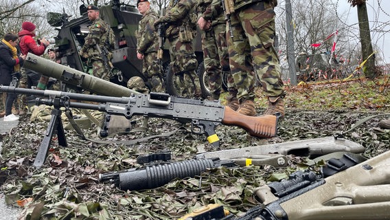 Soldaten posieren neben Waffen auf einem Kasernengelände in Bergen. © NDR Foto: Jon Mendrala