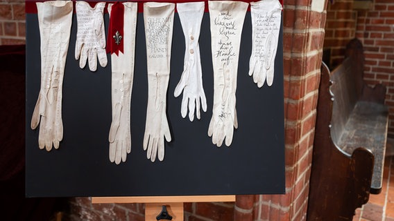 Lüneburg: In der Kirche St. Nicolai sind weiße Handschuhe mit christlichen Worten beschrieben. © dpa-Bildfunk Foto: Philipp Schulze