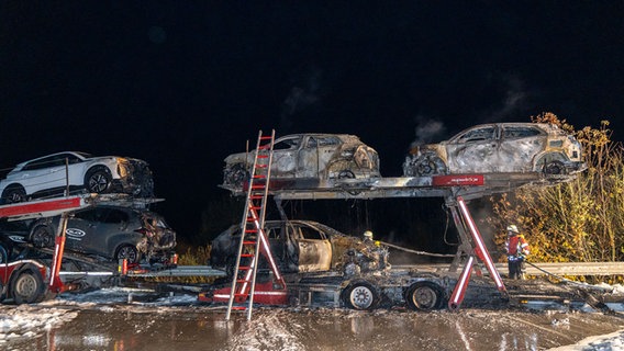 Feuerwehrleute löschen einen brennenden Autotransporter auf der A7. © JOTO 