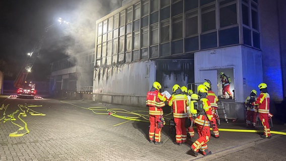 Feuerwehrleute bei einem nächtlichen Einsatz auf dem Gelände eines Joghurtherstellers in Lüneburg. © NDR Foto: Carlo Eggeling